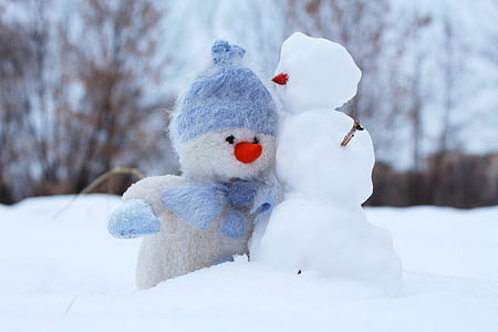 snowman plush toy beside snowman at daytime thumbnail
