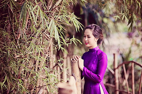 woman standing in front of brown bamboo stick thumbnail