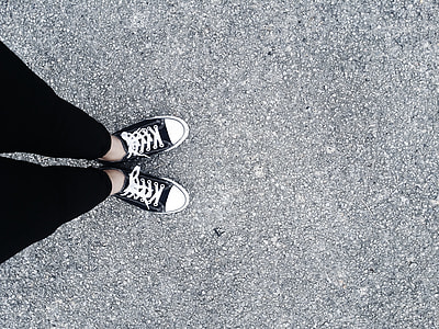 person wearing black pants and pair of black low-top sneakers thumbnail