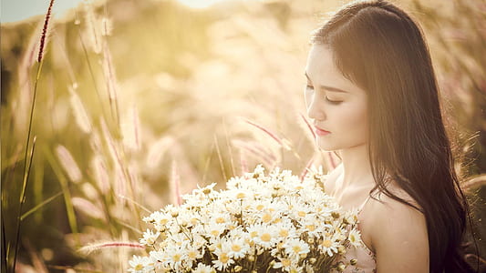 woman holding white daisies thumbnail