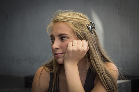 woman resting cheek while sitting thumbnail