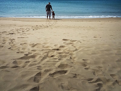 man holding child in front of beach thumbnail
