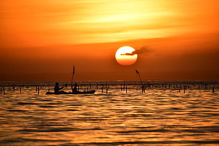 silhouette photography of person riding on boat thumbnail