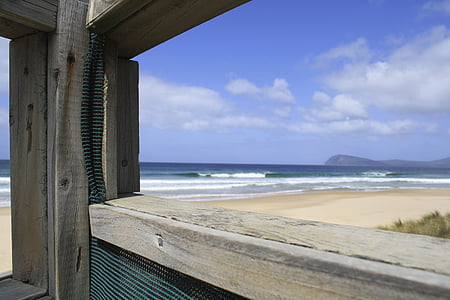 close-up photo of grey wooden stand beside seashore at daytime thumbnail
