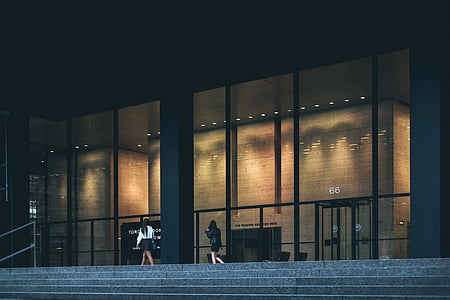 two female beside black concrete building thumbnail