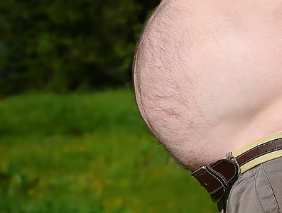 topless man standing near green grass thumbnail