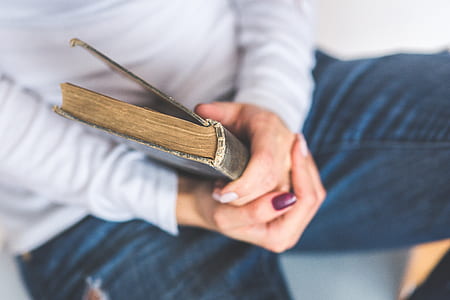 person holding black leather book thumbnail