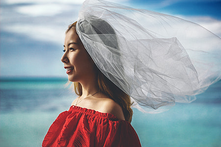 woman wearing white veil in front of body of wate thumbnail