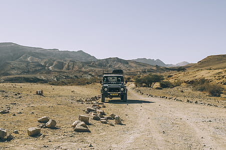 gray Land Rover Defender near brown mountain on daytime thumbnail