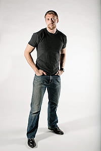 man in black crew-neck shirt and blue-washed jeans thumbnail