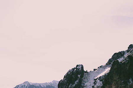 rocky mountain cover with snow under clear white sky thumbnail