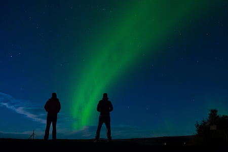 two people standing watching northern lights during nighttime thumbnail