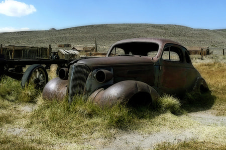 abandoned classic brown car in green grass thumbnail