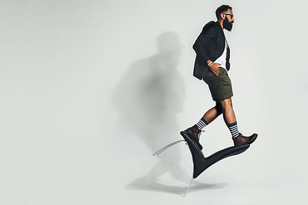 man standing black blazer and green bermuda shorts thumbnail