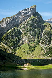 house in front of high mountain beside body of water thumbnail