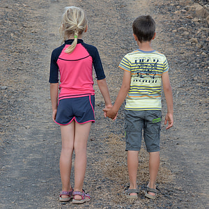boy and girl holding hands during daytime thumbnail