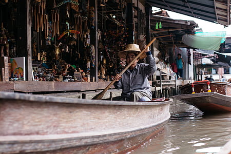 woman ride on boat wearing gray jacket and straw hat thumbnail