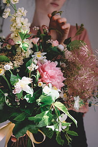 woman in brown top holding pink and white flowers thumbnail