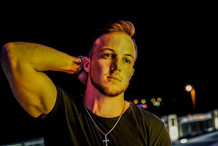 man wearing black shirt standing near building during nighttime thumbnail
