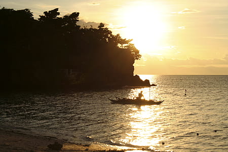 Man in Boat Rowing Near Rock Formation thumbnail