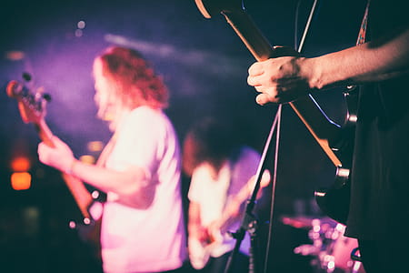 A band on stage with three guitarists playing music thumbnail