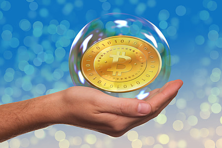 person's left hand holding bubble with Bitcoin inside thumbnail