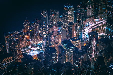 timelapse photography of cars travelling surround by high-rise buildings during nighttime thumbnail