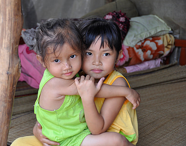two girl hugging while sitting on wicker mat thumbnail