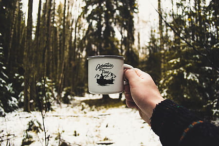 person holding black and white mug thumbnail