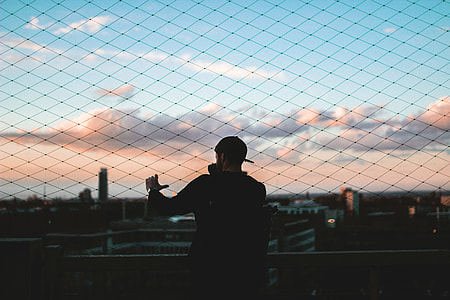 man wearing cap touching barrier thumbnail