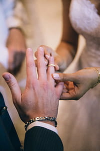Bride putting wedding ring on the groom s finger in church thumbnail