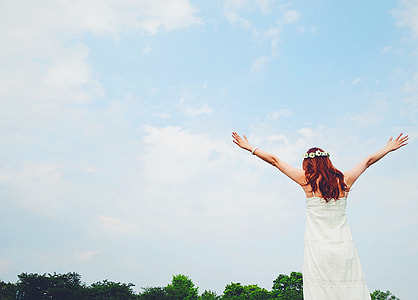 woman wearing white dress raising her hands thumbnail