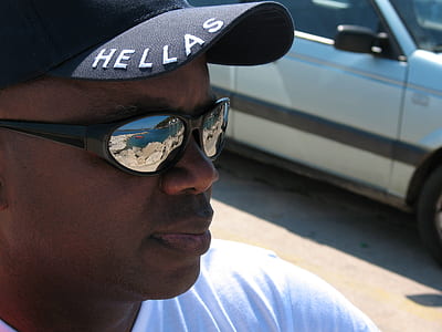 man wearing sunglasses looking away at camera thumbnail