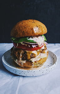 portrait photography of burger on white and black ceramic plate thumbnail