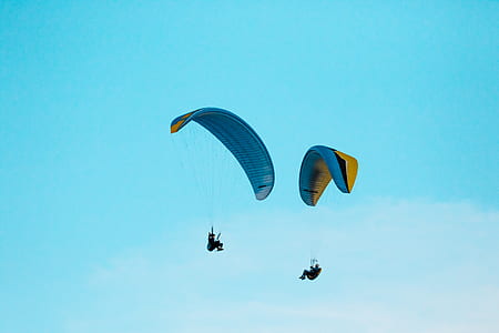 low-angle photo of two person paragliding thumbnail