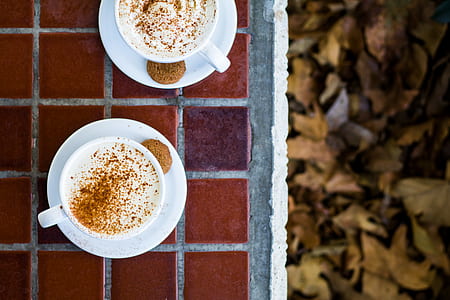 flat lay photography of two mugs on brown tile flooring thumbnail