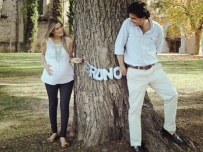 man and woman standing under tree thumbnail