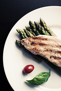 grilled on meat on top of asparagus served on plate thumbnail
