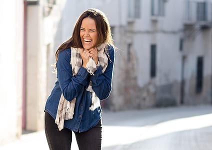 woman laughing near high rise building during daytime thumbnail