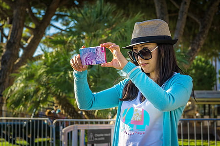 selective focus photo of woman holding blue smartphone thumbnail