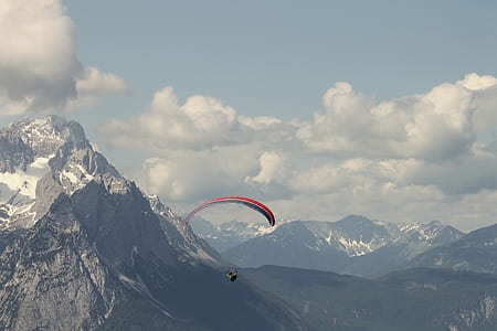 red and green air gliding near mountain thumbnail