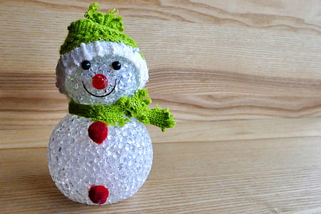 snowman glass figurine on brown wooden surface thumbnail
