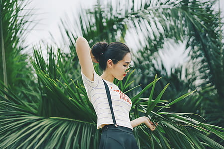 woman wearing white top behinde leafed tree thumbnail