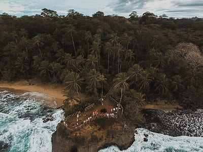 group of peoples on rock formation on body of water thumbnail