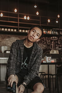 man sitting on chair holding DSLR camera thumbnail