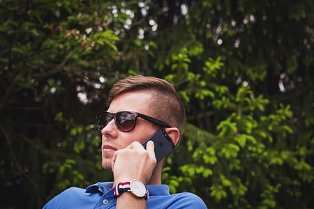 selective focus photography of man holding iPhone thumbnail