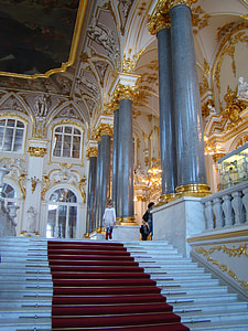 girl standing on red and white stairs inside building thumbnail