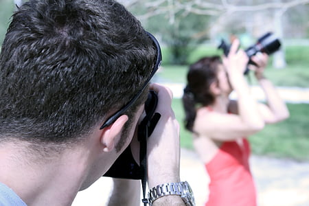 man and woman using cameras thumbnail