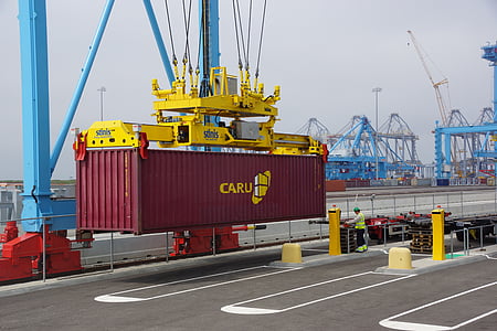 yellow machine lifting red cargo crate on shipping deck thumbnail