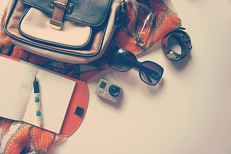 silver and black action camera near sunglasses and notebook thumbnail